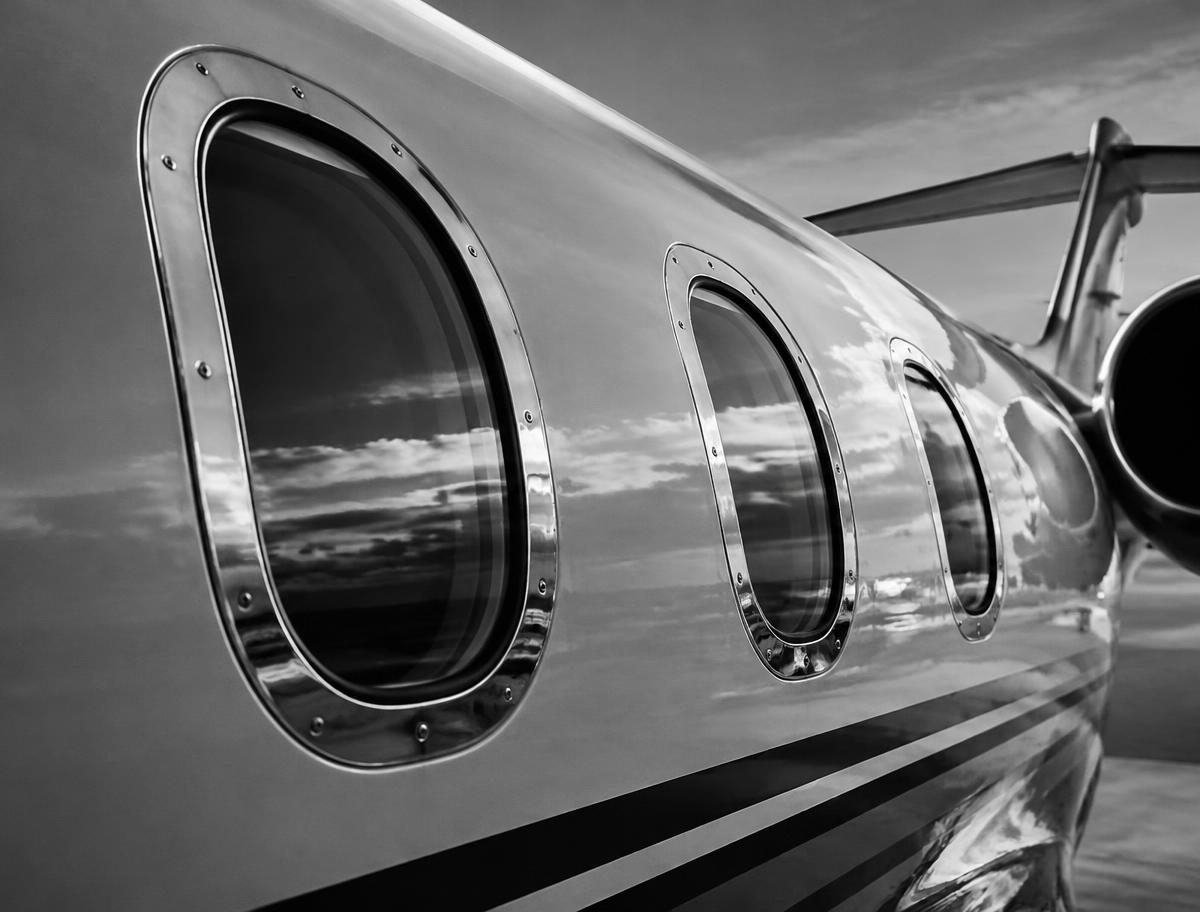 Illustrative monochrome close-up of business jet cabin windows